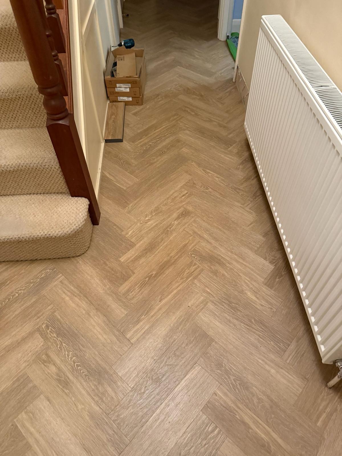 Amtico Form Fawn Oak herringbone through hallway and living spaces.