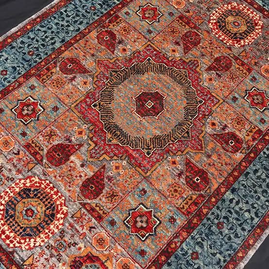 Handwoven patterned rug in deep reds and blues